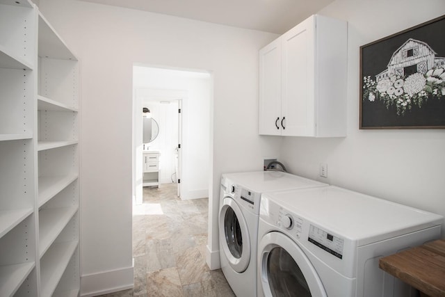 laundry room featuring washer and clothes dryer and cabinets