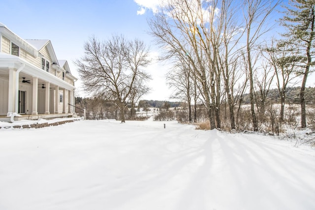 snowy yard featuring ceiling fan