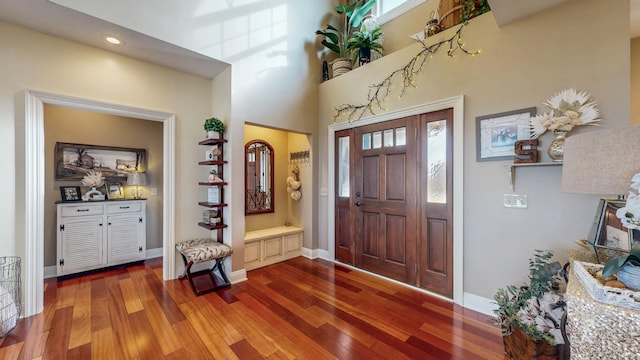 entryway featuring a high ceiling, wood finished floors, and baseboards