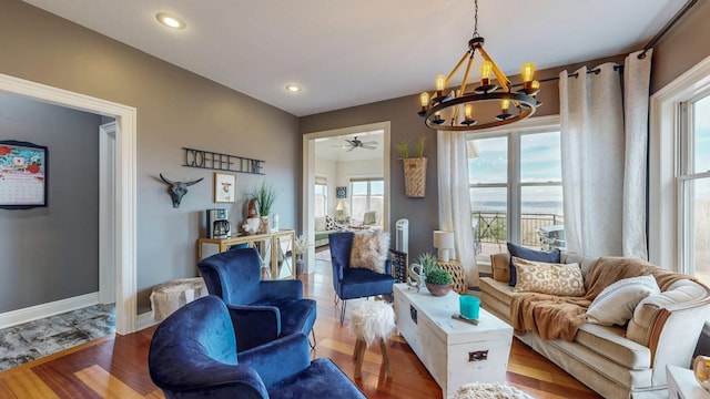 interior space featuring ceiling fan with notable chandelier, recessed lighting, baseboards, and wood finished floors