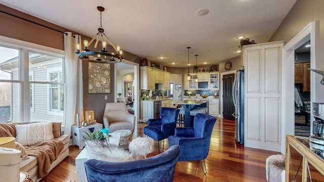 living room featuring recessed lighting, dark wood finished floors, and a notable chandelier