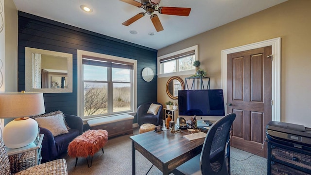 office space featuring carpet, wooden walls, a ceiling fan, and recessed lighting