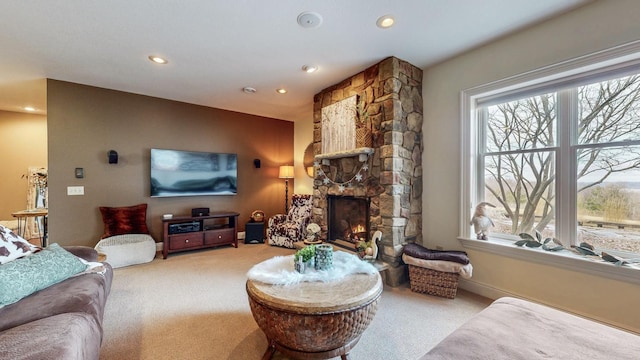 carpeted living room featuring baseboards, a stone fireplace, plenty of natural light, and recessed lighting