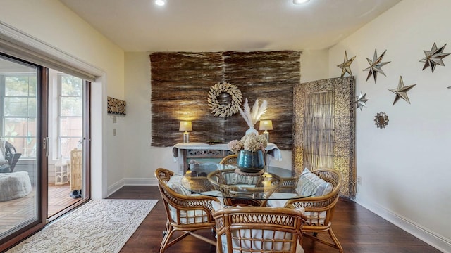 dining space with baseboards, wood finished floors, and recessed lighting