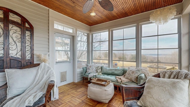 sunroom with wood ceiling and a ceiling fan