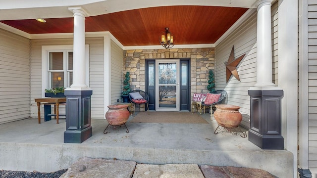 doorway to property featuring stone siding and a porch