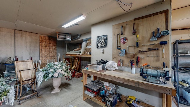 miscellaneous room with concrete flooring and a workshop area