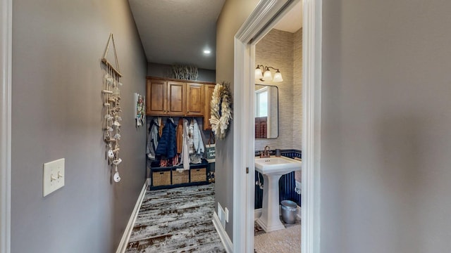 hallway featuring baseboards and wood finished floors