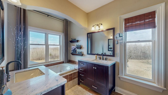 full bathroom with two vanities, a garden tub, a sink, and tile patterned flooring