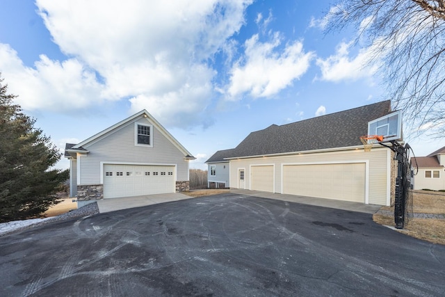 30150 715th St, Lake City, MN 55041 - view of property exterior featuring asphalt driveway, stone siding, an outdoor structure, and a garage