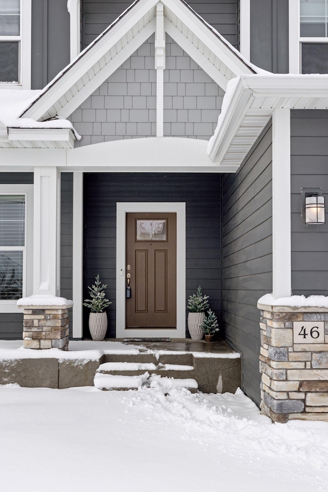 snow covered property entrance featuring covered porch