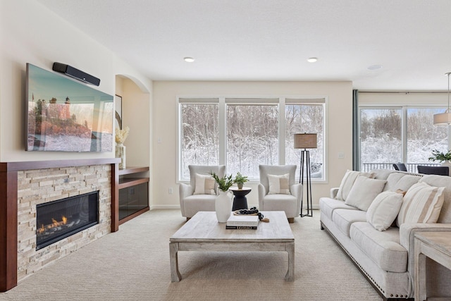 living area featuring carpet flooring, a fireplace, and baseboards