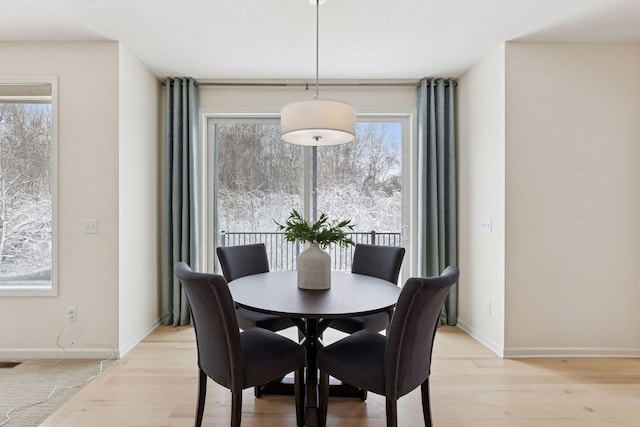 dining room featuring light wood-type flooring and baseboards