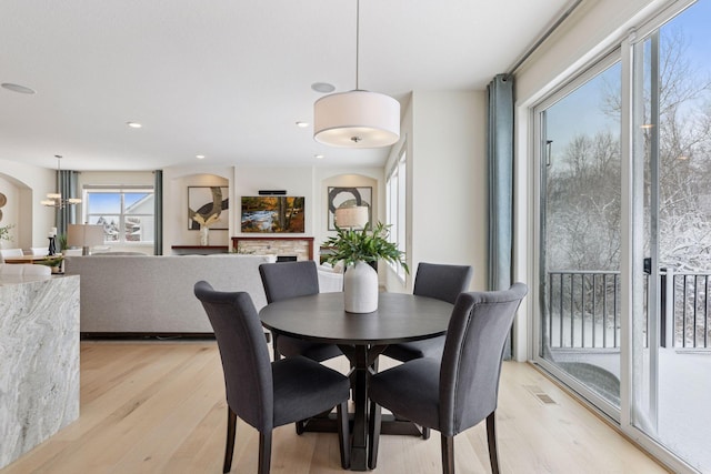 dining area with recessed lighting, a fireplace, and light wood-style flooring