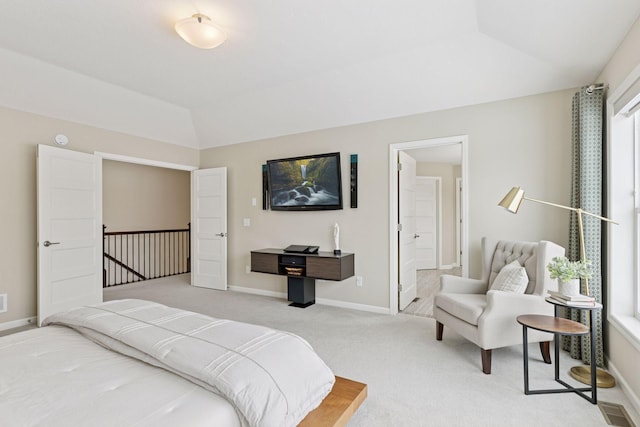 bedroom with visible vents, light carpet, vaulted ceiling, ensuite bath, and baseboards