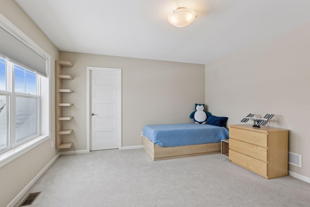 carpeted bedroom featuring visible vents and baseboards