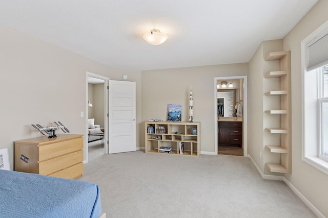 carpeted bedroom featuring multiple windows, ensuite bath, and baseboards