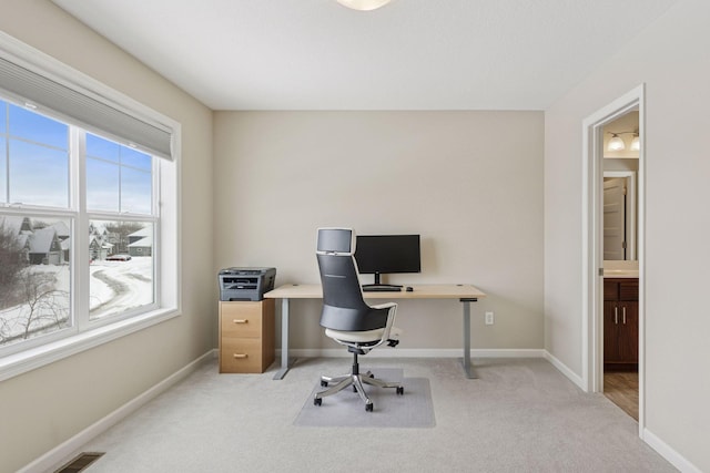 office space featuring visible vents, baseboards, and light colored carpet