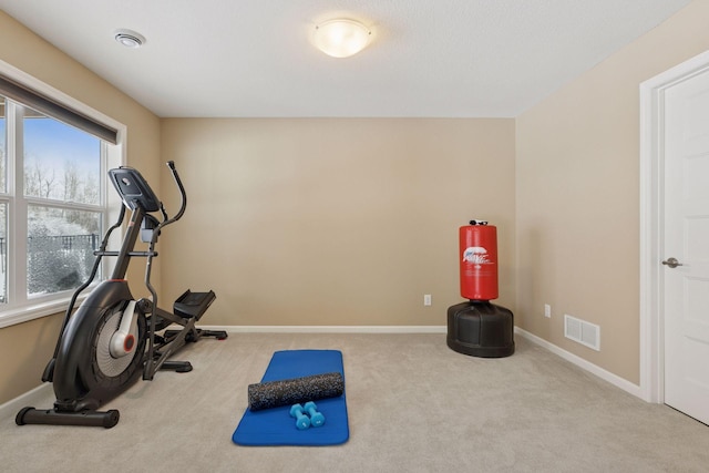 exercise room with baseboards, visible vents, and carpet flooring