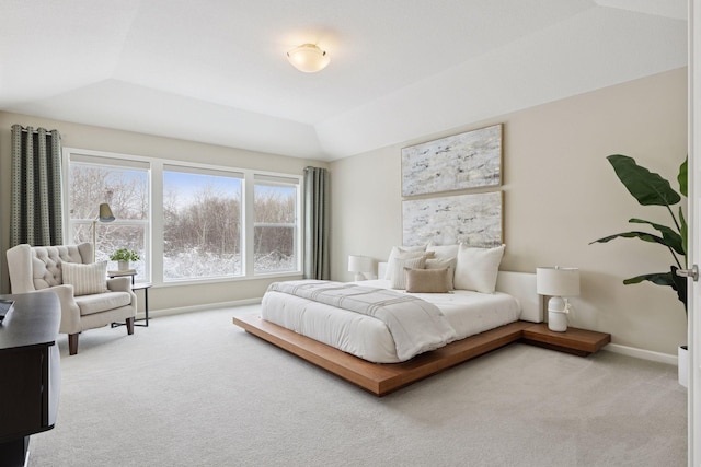 carpeted bedroom with vaulted ceiling and baseboards