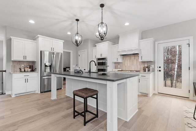 22816 Jarvis St NW, Elk River, MN 55330 - kitchen featuring white cabinetry, pendant lighting, premium range hood, and appliances with stainless steel finishes
