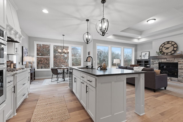 22816 Jarvis St NW, Elk River, MN 55330 - kitchen with light hardwood / wood-style flooring, hanging light fixtures, a notable chandelier, white cabinets, and a center island with sink