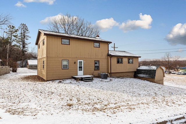 snow covered house featuring cooling unit