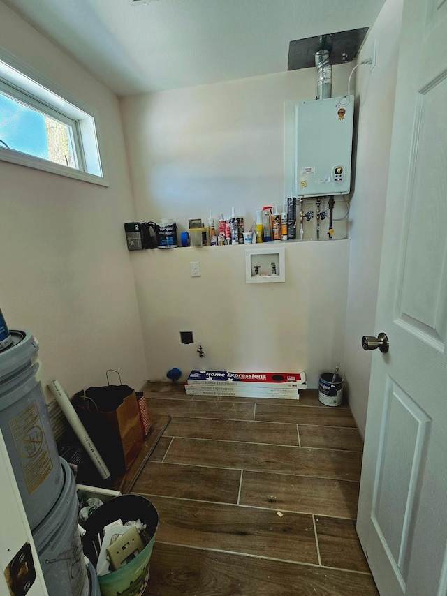 laundry room featuring hookup for a washing machine, dark wood-type flooring, and tankless water heater