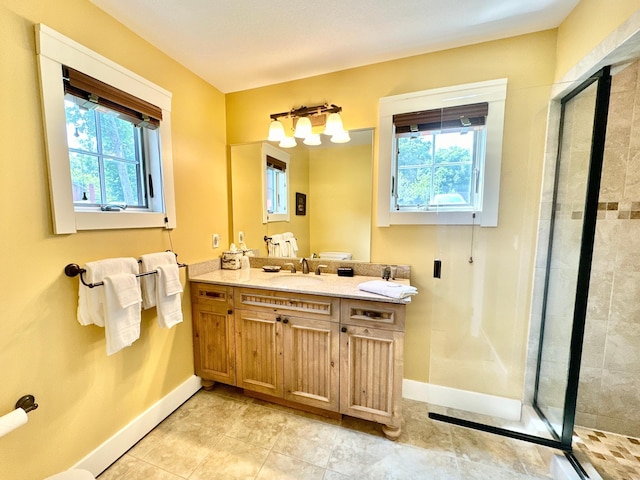 bathroom with an enclosed shower, vanity, and a healthy amount of sunlight