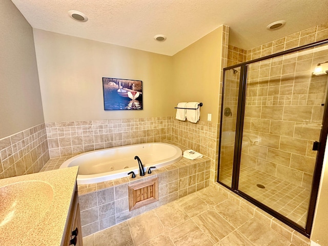 bathroom with vanity, tile patterned floors, a textured ceiling, and plus walk in shower