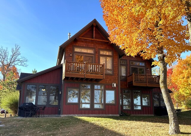 6946 Beach View Ln NW Unit 215-4, Walker, MN 56484 - rear view of house with a yard, a balcony, and board and batten siding