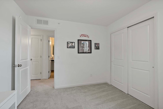 unfurnished bedroom featuring light colored carpet and a closet