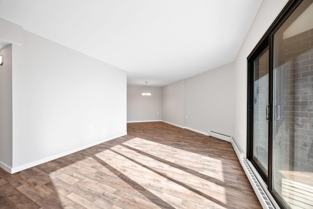 6615 Lake Shore Dr S Unit 311, Richfield, MN 55423 - unfurnished room featuring wood finished floors, a chandelier, and a baseboard heating unit