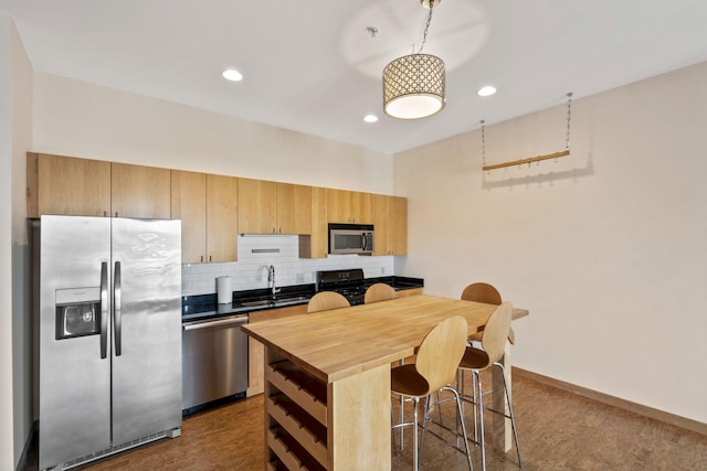 kitchen with stainless steel appliances, a kitchen breakfast bar, sink, and backsplash