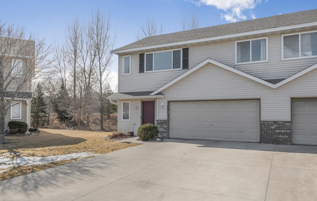 view of front of home with an attached garage, brick siding, driveway, and roof with shingles