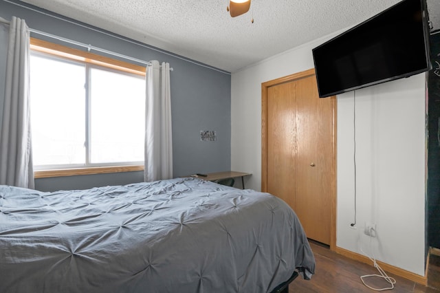 bedroom with ceiling fan, a closet, a textured ceiling, and wood finished floors