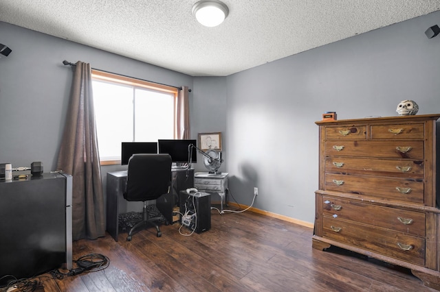 office area with a textured ceiling, dark wood-type flooring, and baseboards