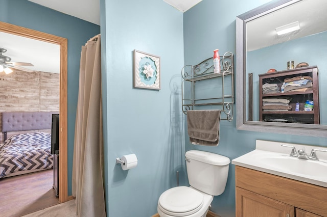 ensuite bathroom featuring connected bathroom, toilet, vanity, and a ceiling fan