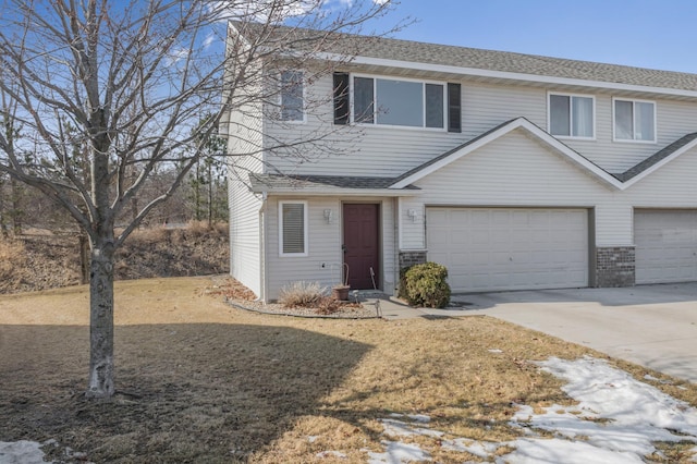 view of front of property featuring a garage, roof with shingles, and driveway