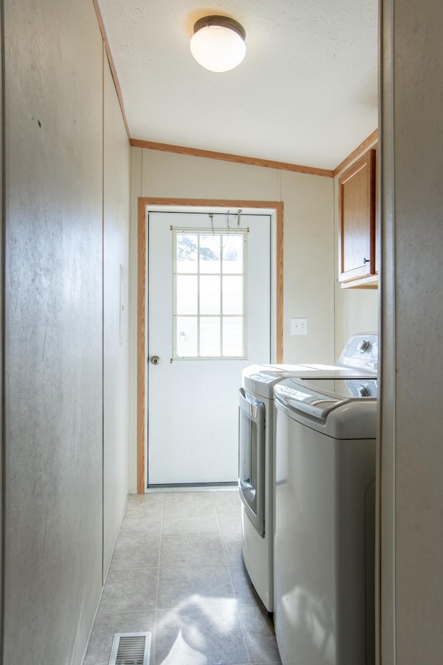 laundry room with visible vents, washing machine and dryer, cabinet space, and crown molding