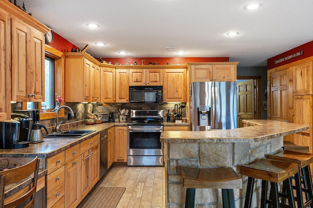 kitchen with sink, a kitchen island, stainless steel appliances, a breakfast bar area, and decorative backsplash