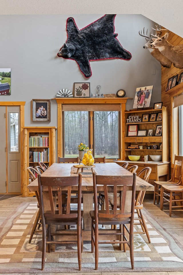 dining space with high vaulted ceiling and a textured ceiling