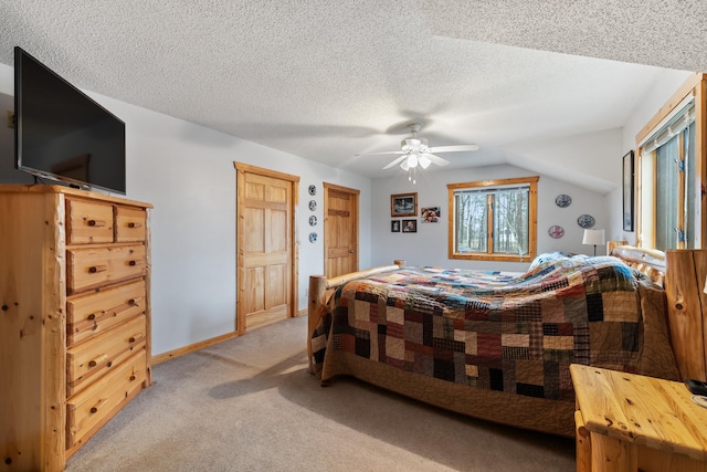 carpeted bedroom with lofted ceiling, ceiling fan, and a textured ceiling