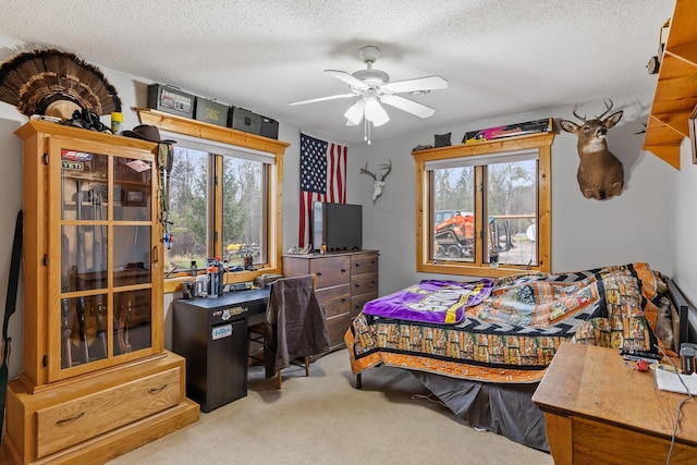 carpeted bedroom featuring ceiling fan and a textured ceiling