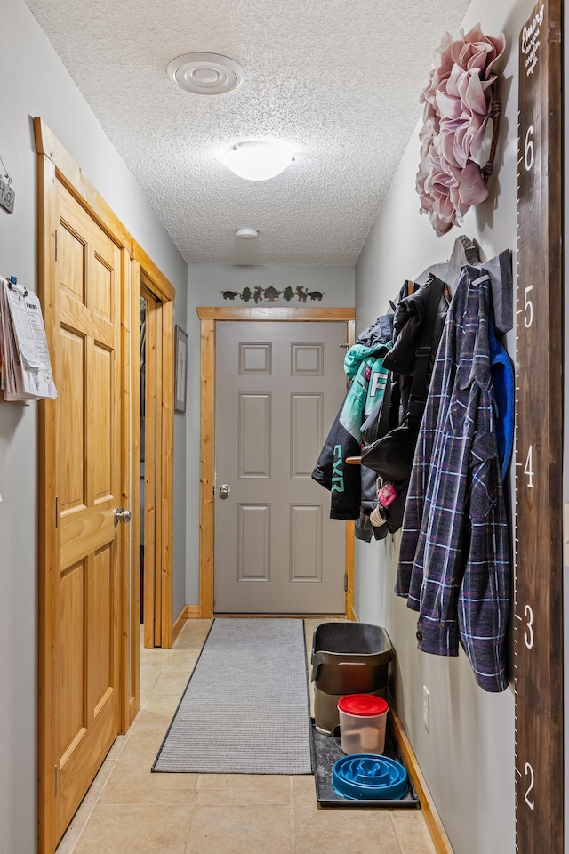 mudroom featuring a textured ceiling and light tile patterned floors