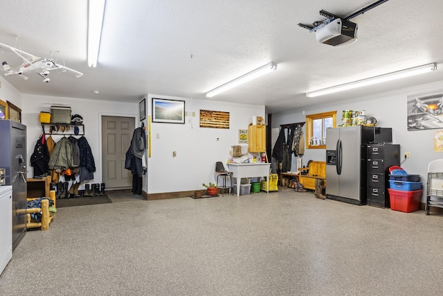 garage with a garage door opener and stainless steel refrigerator with ice dispenser