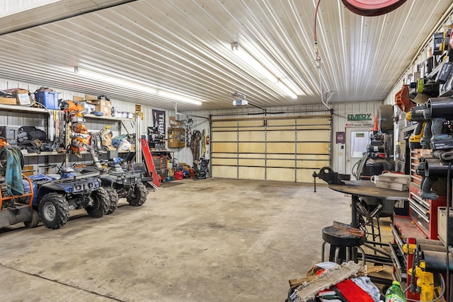 garage with a garage door opener and a workshop area