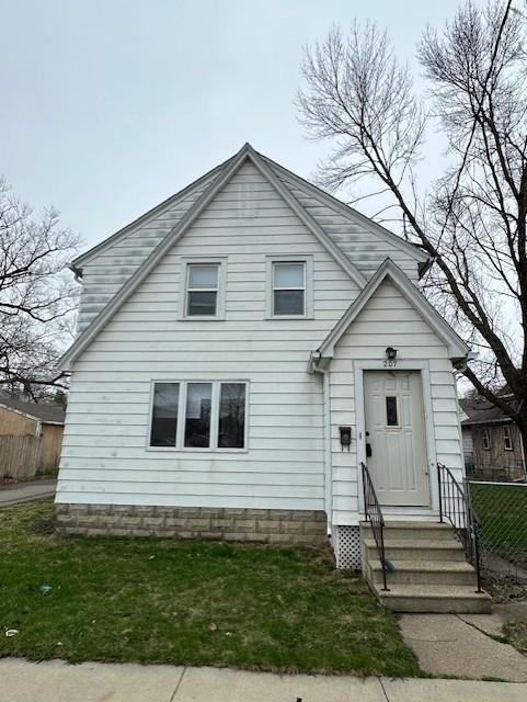 207 7th St SW, Austin, MN 55912 - view of front of property with fence, entry steps, and a front lawn