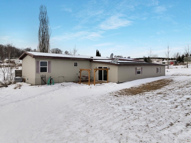 view of snow covered rear of property