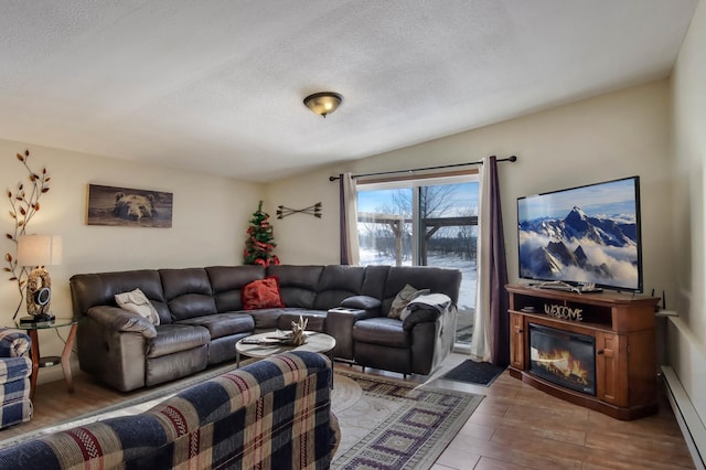 living room featuring a baseboard heating unit, a textured ceiling, and light wood-type flooring